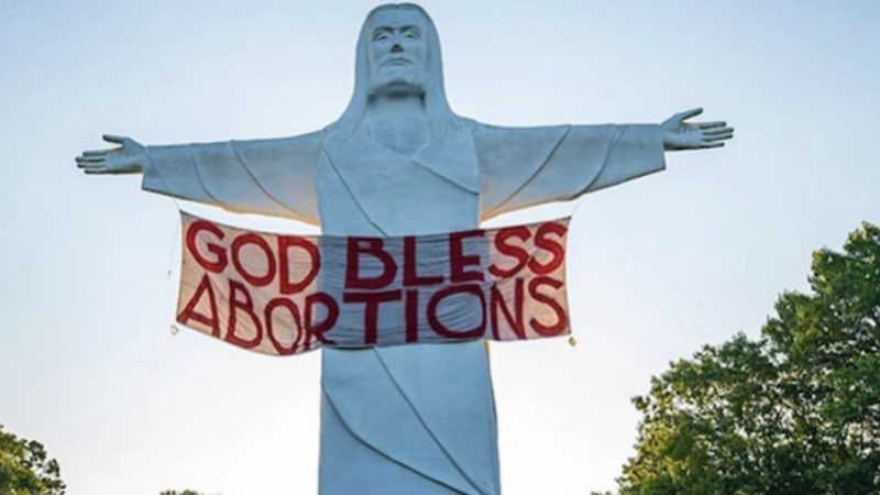 Ativistas penduram faixa “Deus abençoe o aborto” em estátua de Cristo