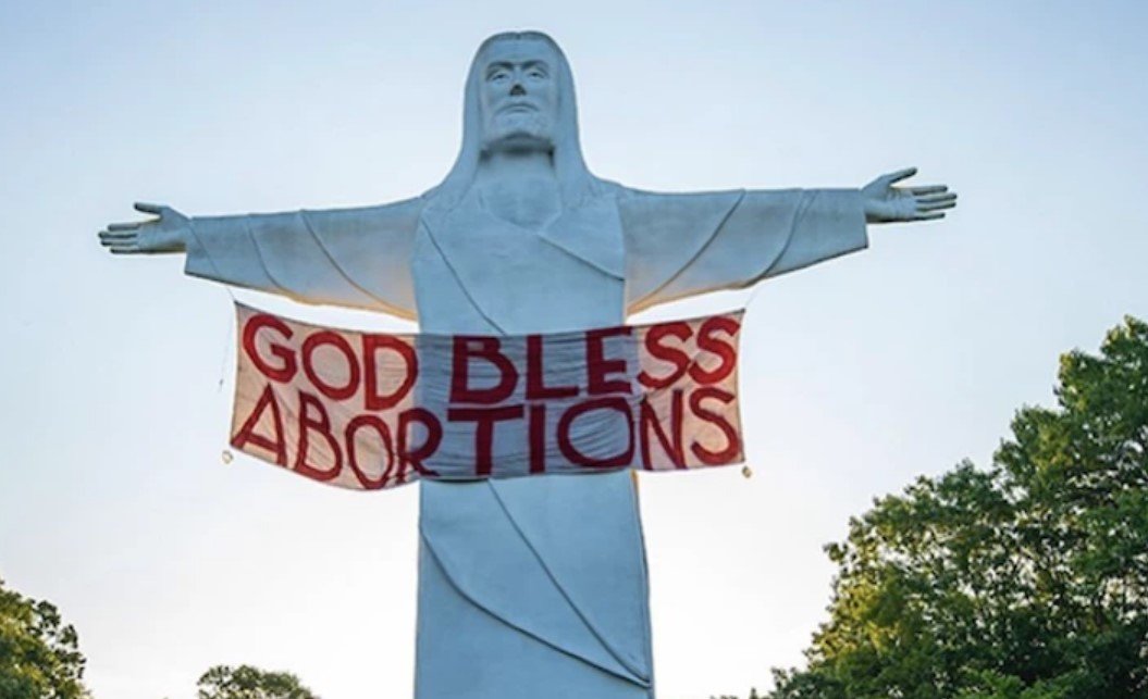 Ativistas penduram faixa “Deus abençoe o aborto” em estátua de Cristo