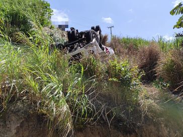 Após caminhão cair em ribanceira, bombeiros trabalham para resgatar vítima de dentro do veículo